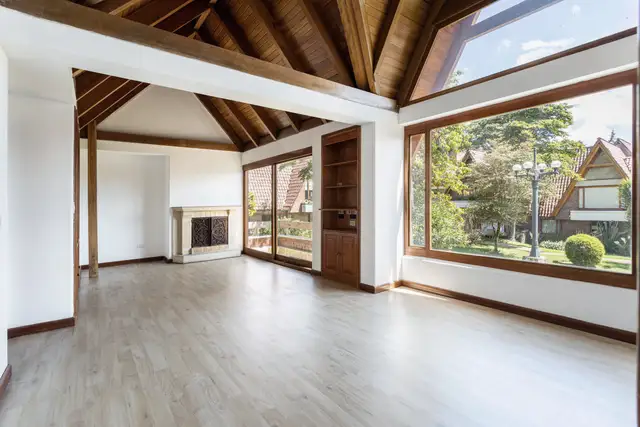 Great room with a vaulted wood ceiling and tall windows